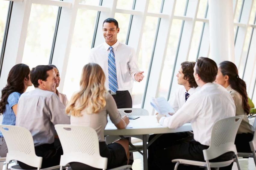 Gruppe von Personen in moderiertem Gespräch am Tisch